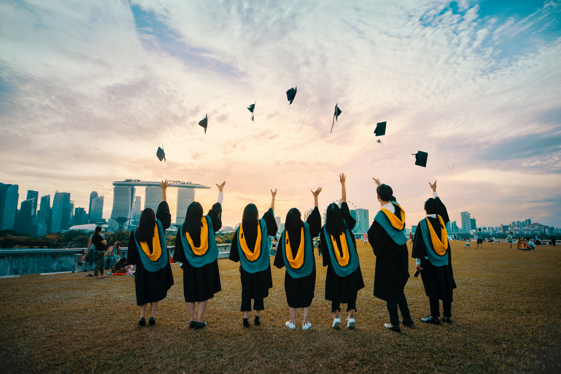 alumnos lanzando birretes de graduación al aire